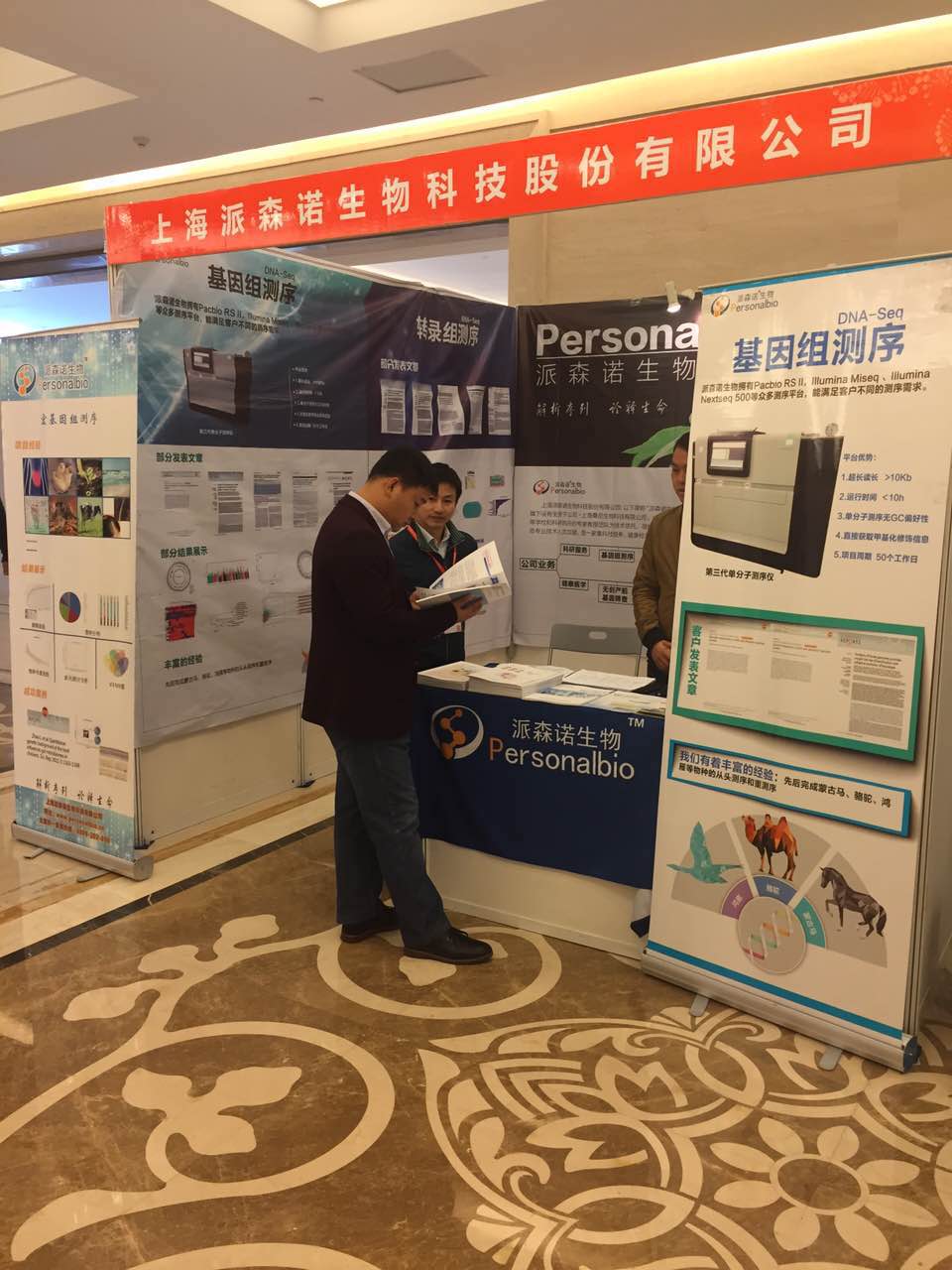 会展现场，用户观看我们的产品手册，叶博士在旁边答疑讲解